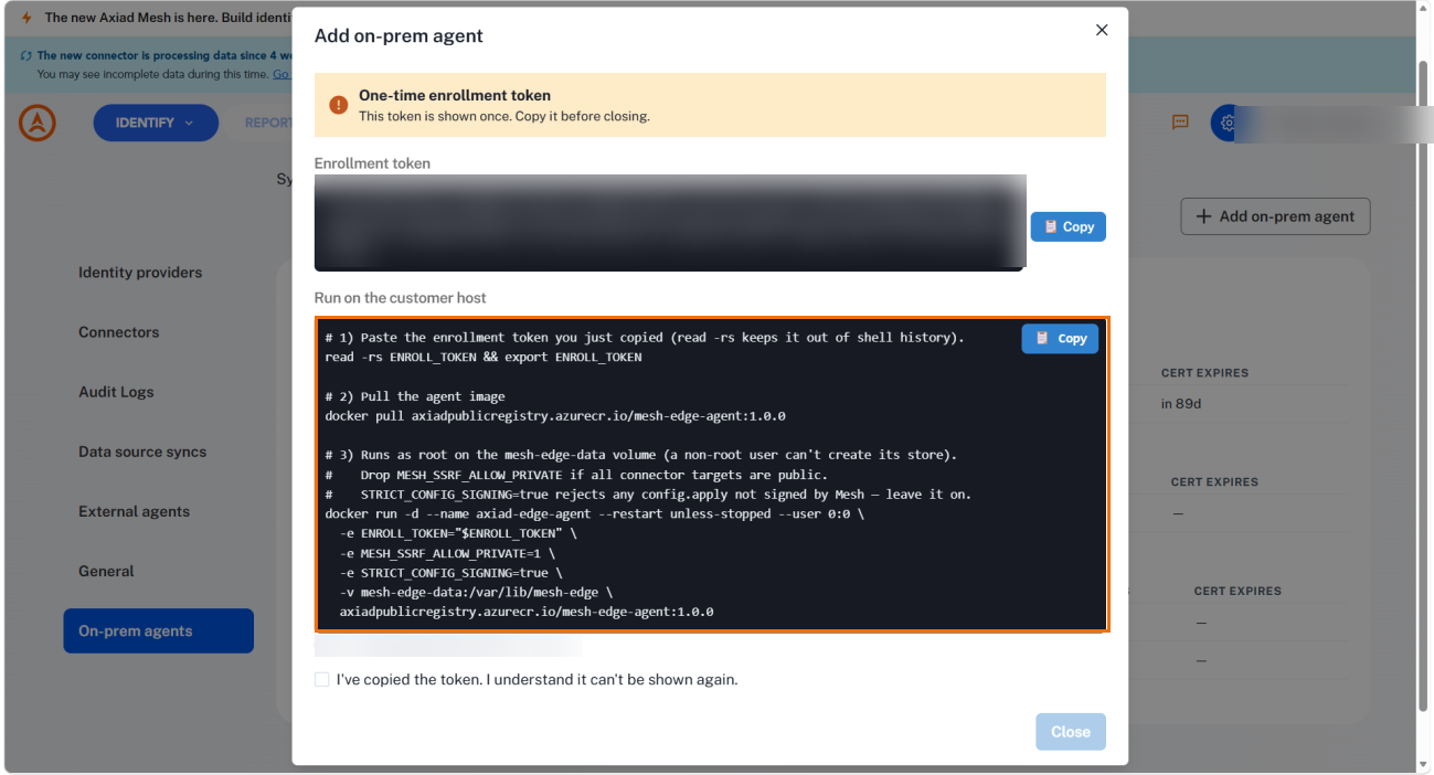 The enrollment token dialog with the token redacted and the Run on the customer host command block highlighted, showing the docker pull and docker run commands